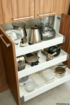 an open cabinet with pots and pans on it