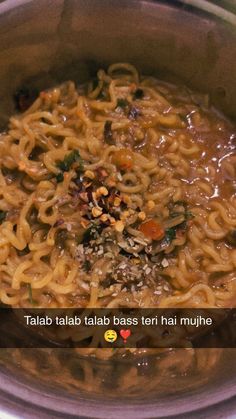 a bowl filled with noodles and vegetables on top of a table