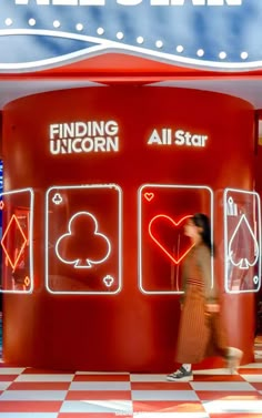 a woman walking past a red and white checkered floor with an all star sign