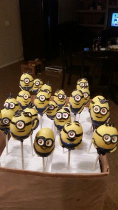 a bunch of minion cupcakes sitting on top of cake pops in a box