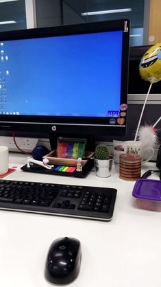 a desktop computer sitting on top of a white desk next to a keyboard and mouse