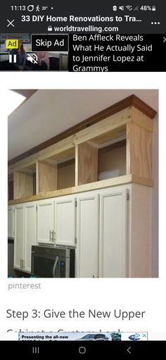 a kitchen with white cabinets and wood trim around the top shelf above the microwave oven