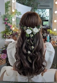 the back of a woman's head with flowers in her hair, sitting at a table