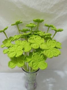 a vase filled with green flowers on top of a white table