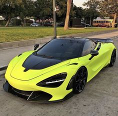 a yellow and black sports car parked on the side of the road next to a curb