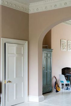 a living room filled with furniture and pink walls