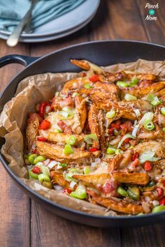 a skillet filled with fried food on top of a wooden table