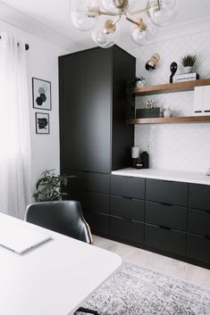 a kitchen with black cabinets and white walls