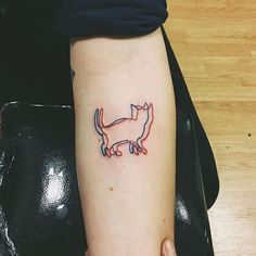 a small cat tattoo on the left arm and leg, it looks like an outline