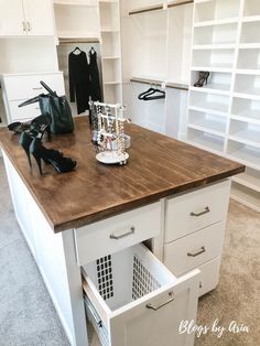 an organized closet with shoes and handbags on the counter, drawers in between them