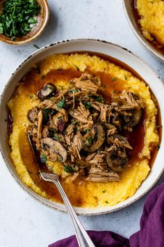 a bowl filled with mashed potatoes topped with meat and mushrooms