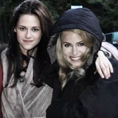 two women are posing for the camera with one woman wearing a black hat and scarf