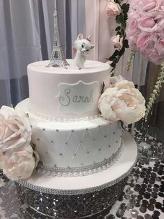 a three tiered cake decorated with flowers and the eiffel tower in paris