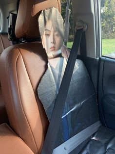 the back seat of a car with a woman's face on it and an ad taped to the side