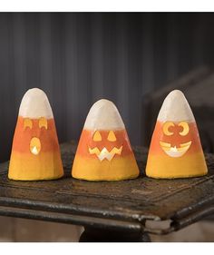 three pumpkin shaped candles sitting on top of a table