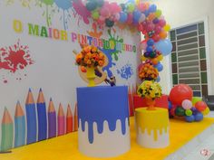 there are many colorful balloons and flowers on the table with crayons around it