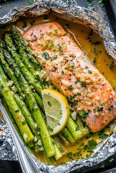 grilled salmon and asparagus in foil with lemon wedges on the side