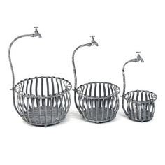 two metal baskets sitting next to each other on top of a white surface with water spouting from them