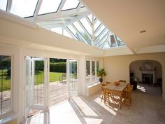 a dining room with an open roof and glass doors leading to the outside patio area