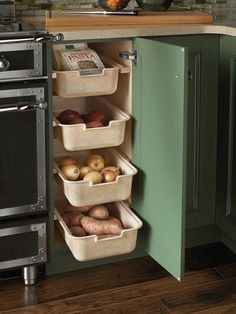 a kitchen with green cabinets and an oven in the corner that has three bins on it