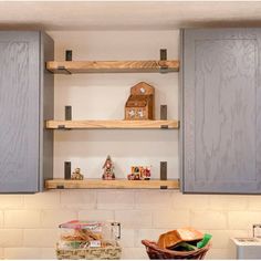 a kitchen with gray cabinets and wooden shelves