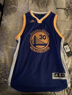 the golden state warriors jersey is displayed on a bed