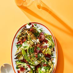 a white plate topped with shaved brussels sprouts next to an orange table cloth