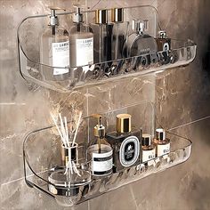 a bathroom shelf with soaps, lotions and other items on it in front of a marble wall