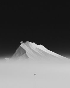 a person standing on top of a snow covered mountain in the middle of foggy weather