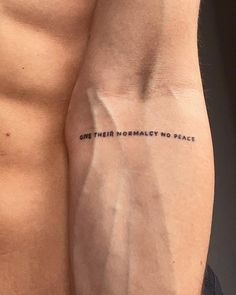 a close up of a person with a tattoo on his arm and the words, one world democracy no peace