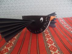 a paper bird sitting on top of a bed