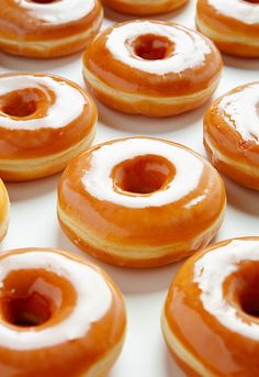 many glazed donuts with white frosting on them