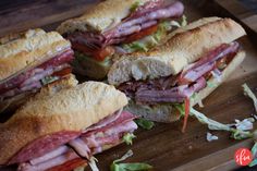 a cut in half sandwich sitting on top of a wooden cutting board