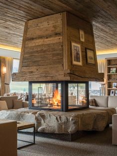 a living room filled with furniture and a fire place in the middle of it's fireplace