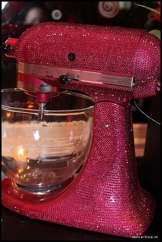 a red mixer with a glass bowl on it