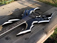 a black and white guitar sitting on top of a wooden bench