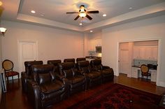 an empty theater room with leather recliners