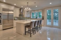 a large kitchen with an island and lots of stools in front of the counter