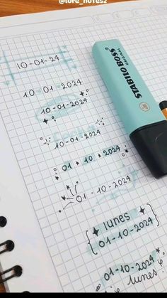 a pen sitting on top of a notebook next to an eraser with numbers written on it