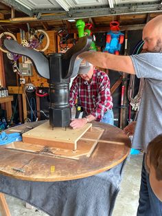 two men working on an object in a garage