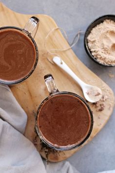 two glasses of hot chocolate on a cutting board