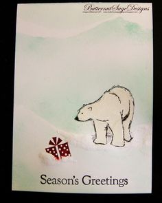 a card with a polar bear holding a present in it's paws and the words season's greetings written below