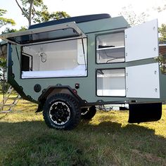 an off road camper is parked in the grass