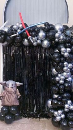 star wars balloon arch with yoda and darth vader figurine on it