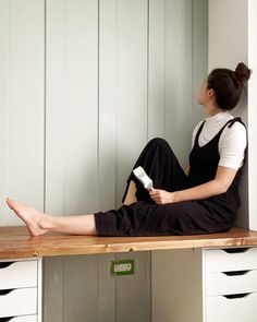 a woman sitting on top of a wooden desk