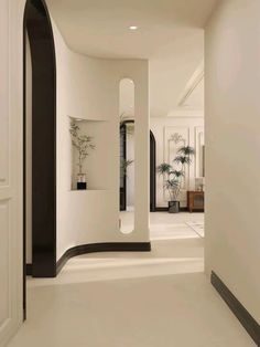 an empty hallway with white walls and black trim