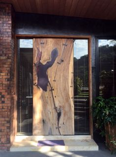 a wooden door that is on the side of a brick building with glass and wood