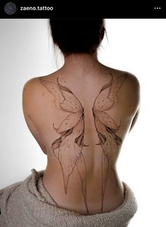 the back of a woman's body with tattoos on it