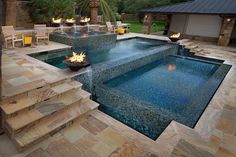 an outdoor swimming pool with steps leading up to it and fire pit in the middle