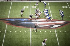 a football game is being played on the field with players in uniform and numbers painted on it